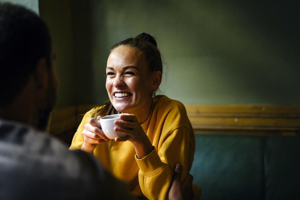 Smiling woman holding teacup.