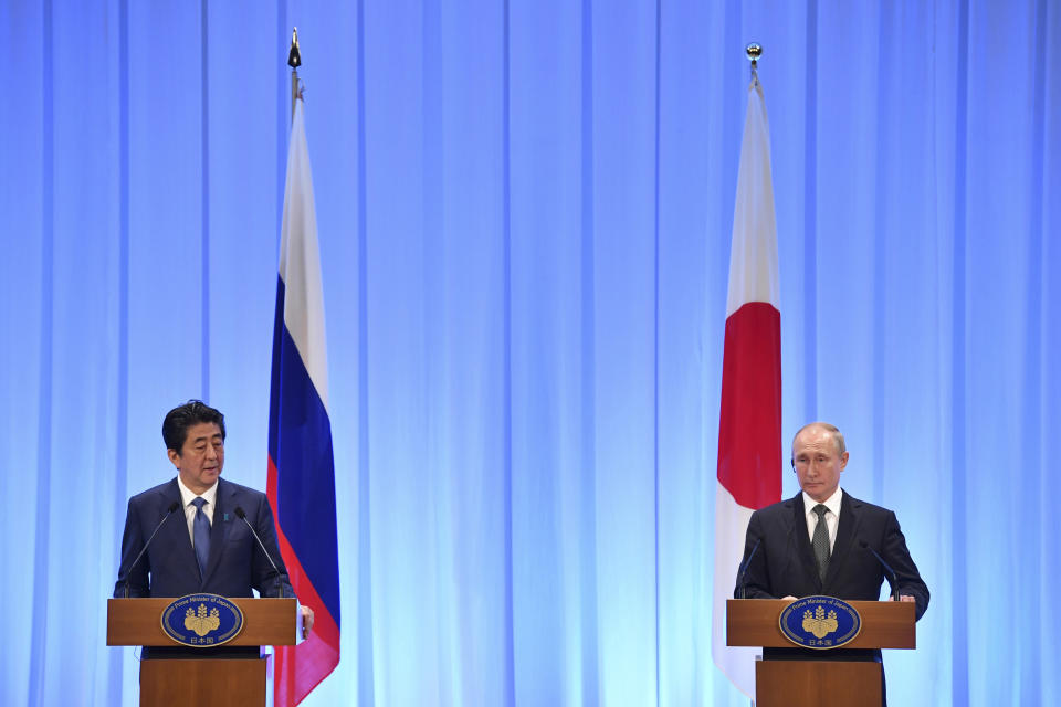 Japan's Prime Minister Shinzo Abe, left, speaks beside Russia's President Vladimir Putin at a press conference after the G20 Summit in Osaka, Japan, Saturday, June 29, 2019. (Yuri Kadobnov/Pool Photo via AP)