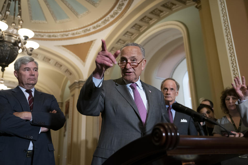 Senate Minority Leader Chuck Schumer, D-N.Y., flanked by Sen. Sheldon Whitehouse, D-R.I., left, and Sen. Tom Carper, D-Del., condemns remarks by President Donald Trump as he speaks to reporters following a Democratic policy meeting, at the Capitol in Washington, Tuesday, July 16, 2019. (AP Photo/J. Scott Applewhite)