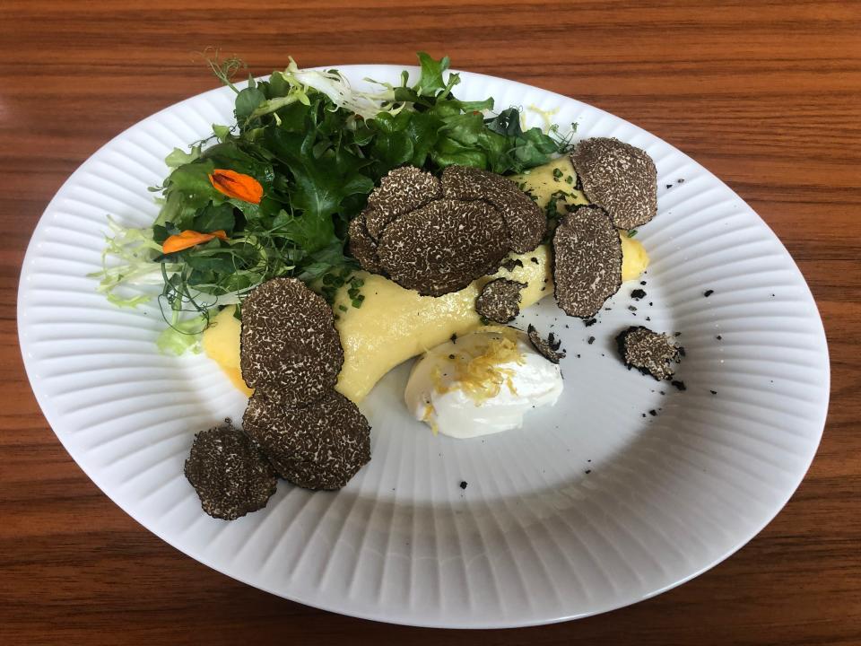 French omelet with shaved burgundy truffles and salad is served at The Continental.