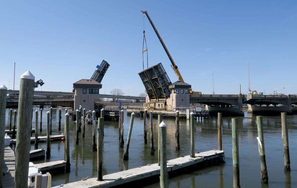 A crane holds the north leaf of the Route 71 bridge over the Shark River, between Belmar (right) and Avon-By-The- Sea, in an open position Tuesday, March 12, 2024. The bridge was stuck in the closed position, blocking boat access to the ocean.