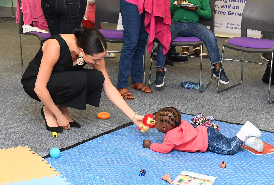 CAPE TOWN, SOUTH AFRICA - SEPTEMBER 25:  Meghan, Duchess of Sussex plays with 15 month old Asivile as she visits mothers2mothers during her royal tour of South Africa with Prince Harry, Duke of Sussex on September 25, 2019 in Cape Town, South Africa. mothers2mothers (m2m) is an African not-for-profit organisation with the vision of a healthy, HIV-free Africa. The organisation trains and employs women living with HIV as frontline health workers across eight African nations.  (Photo by Paul Edwards - Pool/Getty Images)