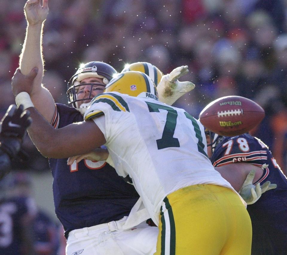 Chicago Bears quarterback Jim Miller is drilled by Green Bay Packers defensive lineman Santana Dotson.