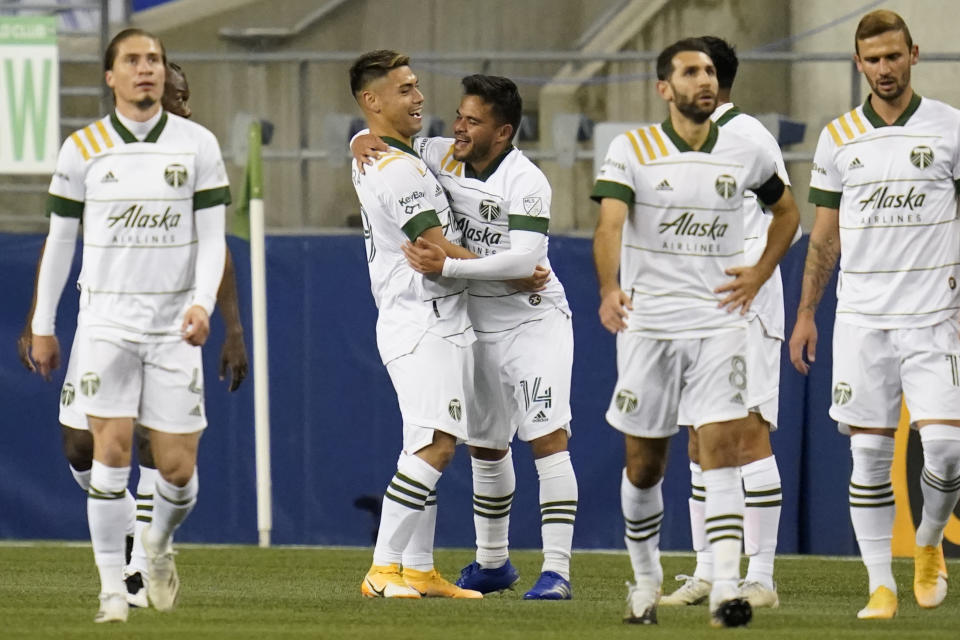Portland Timbers' Andres Flores (14) is congratulated after scoring against the Seattle Sounders in the first half of an MLS soccer match Thursday, Oct. 22, 2020, in Seattle. (AP Photo/Elaine Thompson)