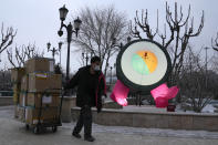 A delivery man pulls a cart load of goods at a mall in Beijing, China, Thursday, Jan. 20, 2022. The sweeping "zero-tolerance" policies that China has employed to protect its people and economy from COVID-19 may, paradoxically, make it harder for the country to exit the pandemic. (AP Photo/Ng Han Guan)