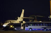 A bus and a van are parcked in front of a plane carrying three Iranian-Americans, who left Tehran under a prisoner swap, after it landed at Cointrin airport in Geneva, Switzerland January 17, 2016. REUTERS/Denis Balibouse