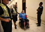A protester is escorted by police away from a demonstration outside Senate Majority Leader Mitch McConnell's constituent office after Senate Republicans unveiled their healthcare bill on Capitol Hill in Washington, U.S., June 22, 2017. REUTERS/Kevin Lamarque