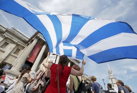 A woman holds the flag of Greece at the 'Greek solidarity festival' in Trafalgar Square, London, Britain, July 4, 2015. REUTERS/Peter Nicholls