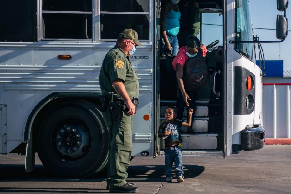 Migrants exit a Border Patrol bus.