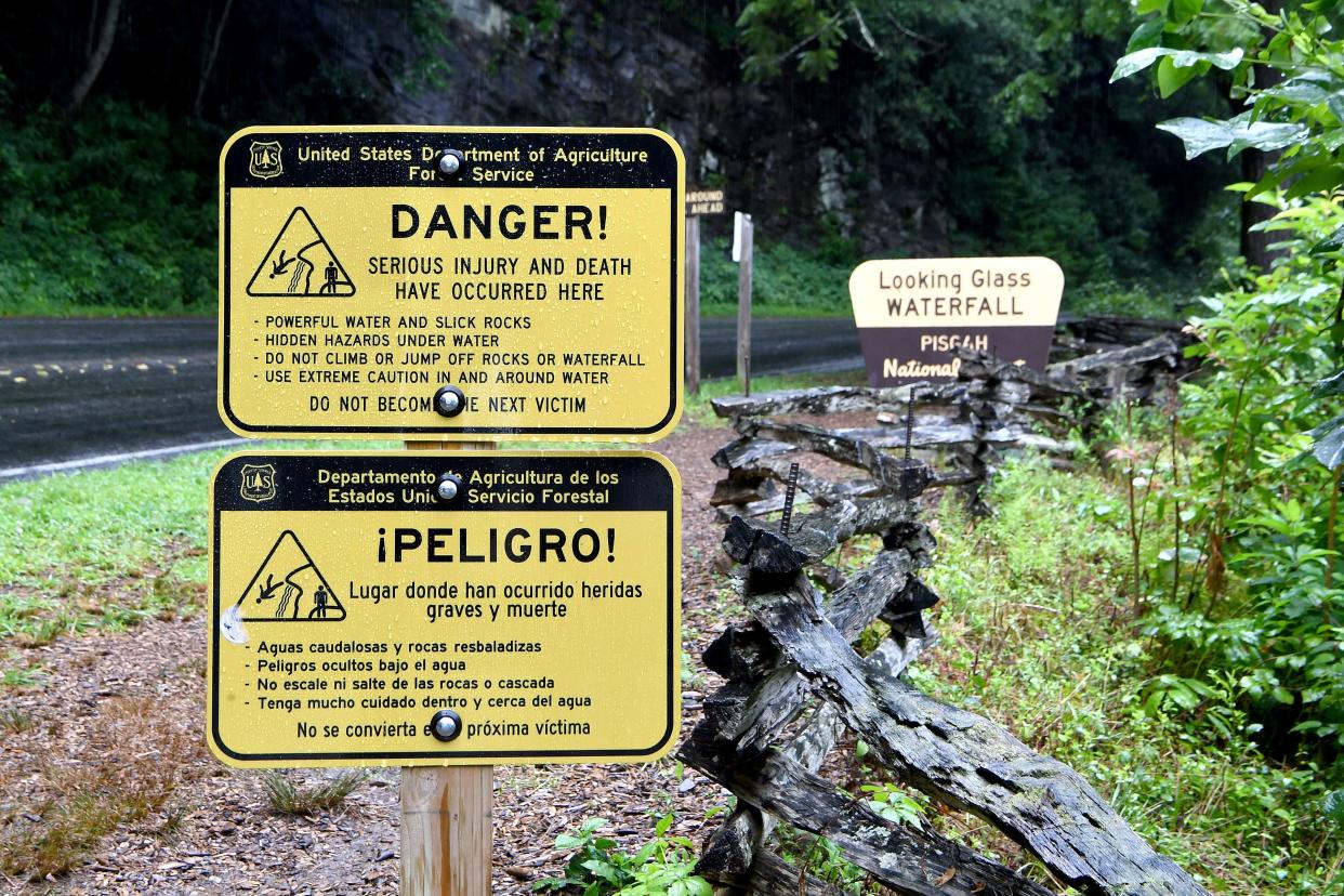 Sign warn of the waterfall's dangers at Looking Glass Falls in the Pisgah National Forest on Thursday, July 19, 2018. 