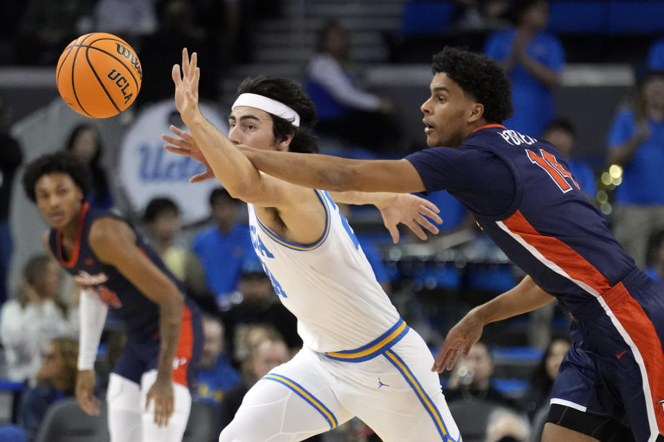 UCLA guard Jaime Jaquez Jr., left, reaches for the ball next to Pepperdine forward Jevon Porter (14) during the first half of an NCAA college basketball game Wednesday, Nov. 23, 2022, in Los Angeles. (AP Photo/Marcio Jose Sanchez)