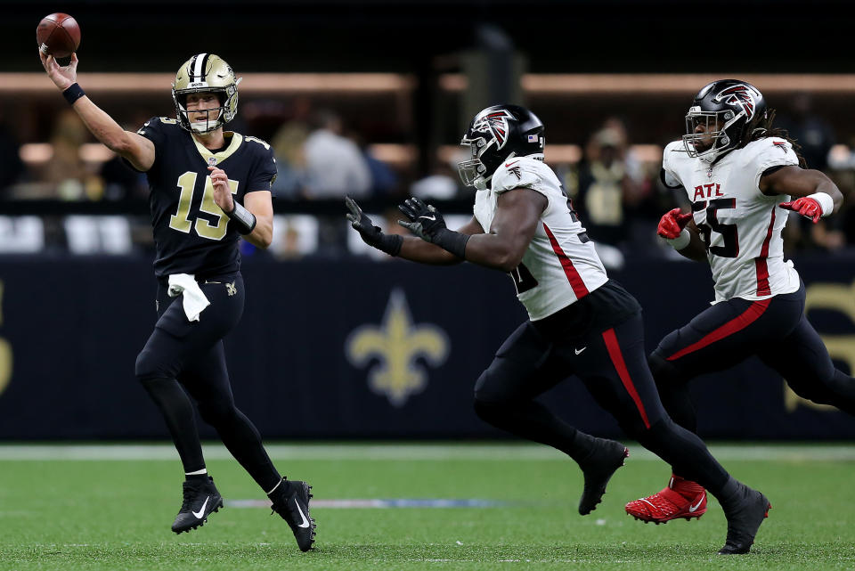 NEW ORLEANS, LOUISIANA - NOVEMBER 07: Trevor Siemian #15 of the New Orleans Saints is chased by John Cominsky #50 and Steven Means #55 of the Atlanta Falcons during the first quarter at Caesars Superdome on November 07, 2021 in New Orleans, Louisiana. (Photo by Jonathan Bachman/Getty Images)