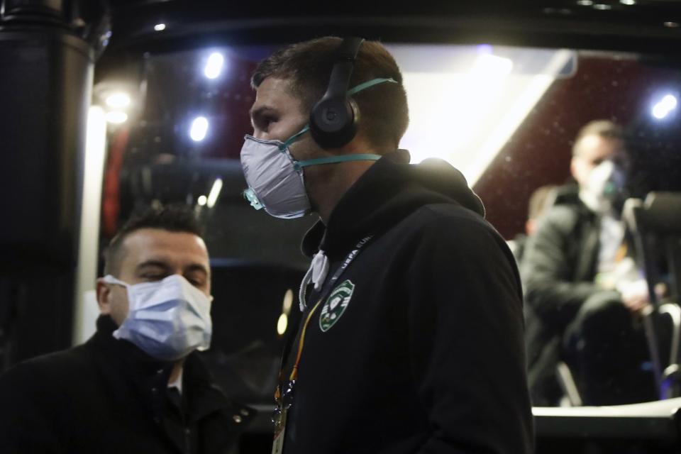 FILE - In this Thursday, Feb. 27, 2020 file photo, Members of the Ludogorets Bulgarian soccer team wearing protective face masks board a bus heading to the San Siro stadium in Milan, Italy. On Friday, Feb. 28, 2020, The Associated Press reported on stories circulating online incorrectly asserting that surgical masks protect against the new coronavirus. The World Health Organization advises that the masks should be worn by those showing symptoms of coughing and difficulty breathing. There is no evidence that masks protect people who are not sick. (AP Photo/Luca Bruno)