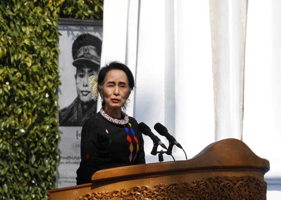 Myanmar State Counsellor Aung San Suu Kyi, standing by a portrait of her late father and national hero Gen. Aung San and the Panglong monument, delivers a speech during a ceremony to mark the 70th anniversary of Union Day Sunday, Feb.12, 2017, in Panglong, Southern Shan State, over 800 kilometers (500 miles) northeast of Yangon, Myanmar. (AP Photo/Thein Zaw)