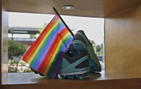 This Thursday, June 20, 2019, photo, shows running shoes on display with a rainbow flag at Red Coyote Running and Fitness in Oklahoma City, to celebrate Pride Month. For Pride month, retailers across the country are selling goods and services celebrating LGBTQ culture. Red Coyote Running and Fitness on Saturday sponsored an inaugural “Love Run” race, complete with rainbow medals. (AP Photo/Sue Ogrocki)