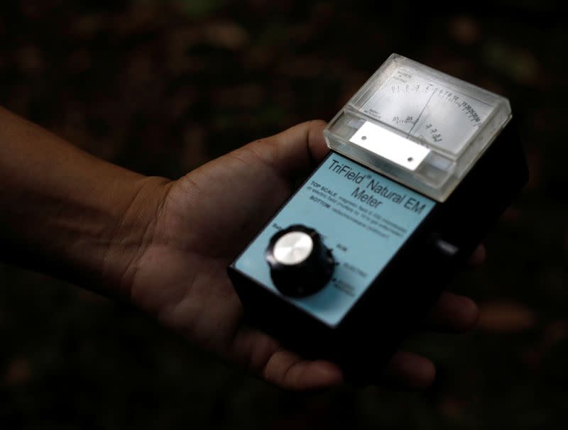 Paranormal investigator Charles Goh shows a gadget that he uses to "track" paranormal activities in Singapore