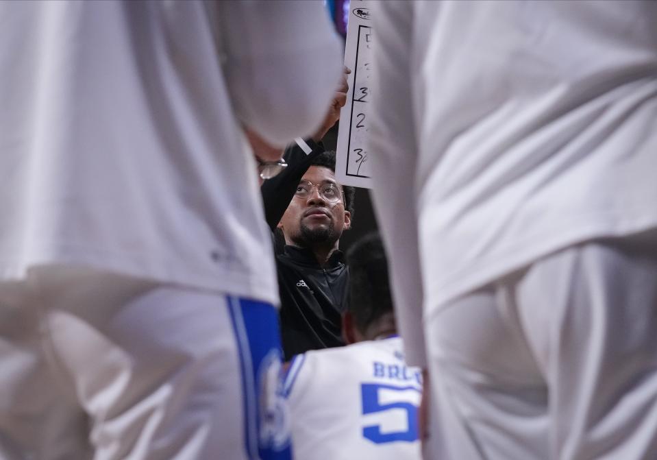 Drake University graduate assistant coach Ayo Akinwole works during a timeout.