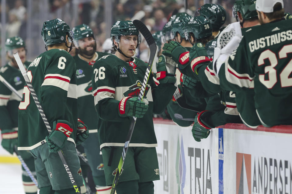 Minnesota Wild center Connor Dewar, center, is congratulated by teammates after his goal against the Los Angeles Kings during the first period of an NHL hockey game Thursday, Oct. 19, 2023, in St. Paul, Minn. (AP Photo/Matt Krohn)