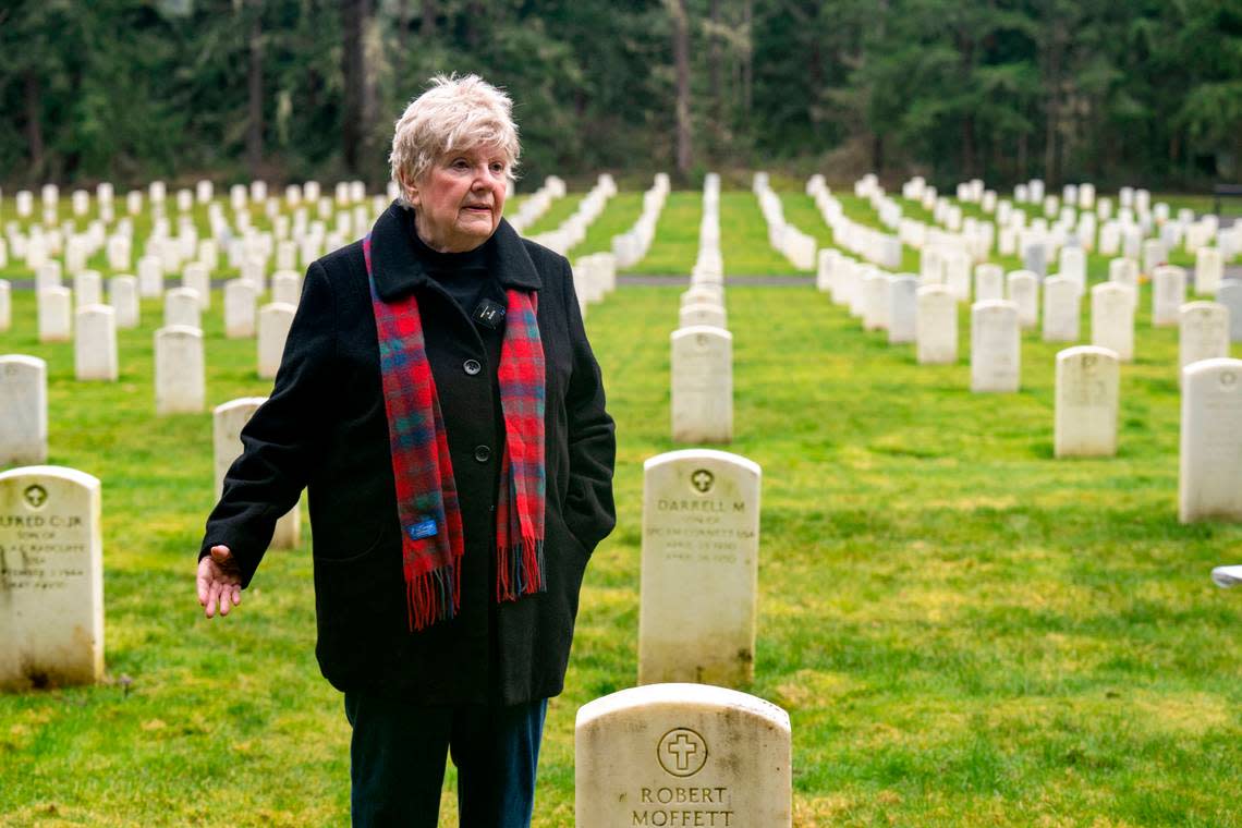 Mary Dowling stands alongside the grave of her husband, Bob, while pointing toward the site where she was supposed to be buried alongside him on Tuesday, Jan. 24, 2023, in the Camp Lewis Cemetery at Joint Base Lewis McChord.