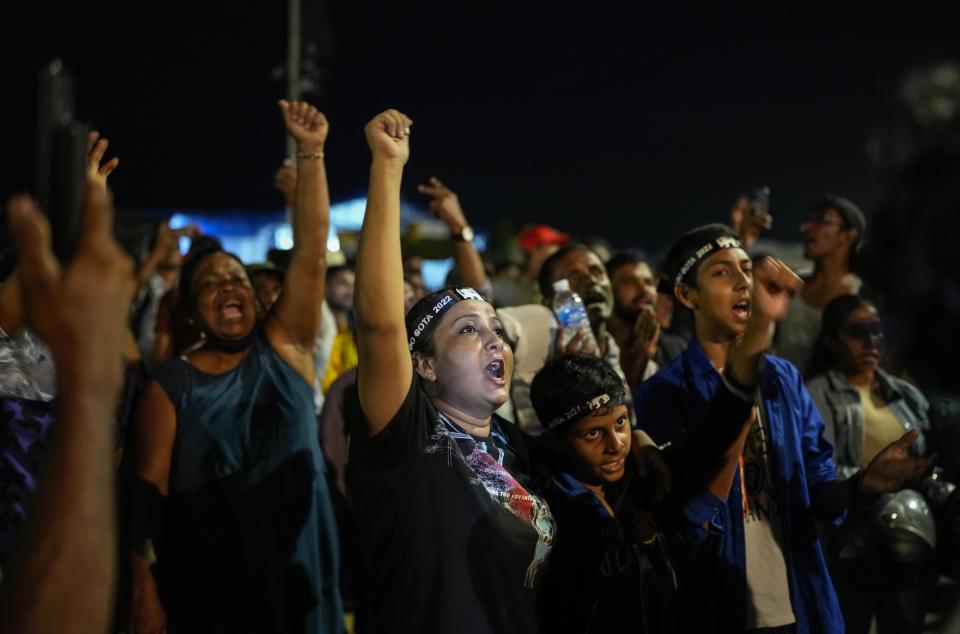 Sri Lankan celebrate as they react to early reports of President Gotabaya Rajapaksa's resignation in Colombo, Sri Lanka, Thursday, July 14, 2022. Embattled Rajapaksa fled a day earlier under pressure from demonstrators furious over the island nation's economic collapse. He finally emailed his resignation Thursday, a day later than promised, according to an official. (AP Photo/Rafiq Maqbool)