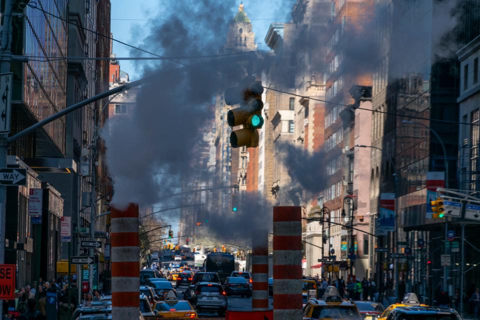 Downtown Manhattan streets covered in cars and smoke.