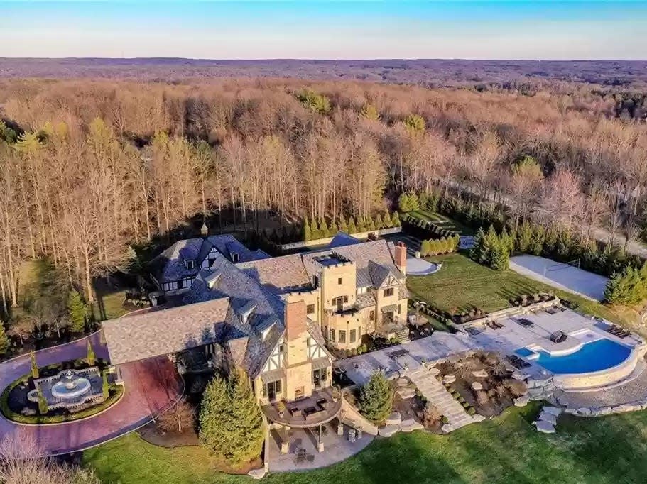 Castle with a circle driveway, pool, and many trees in Ohio