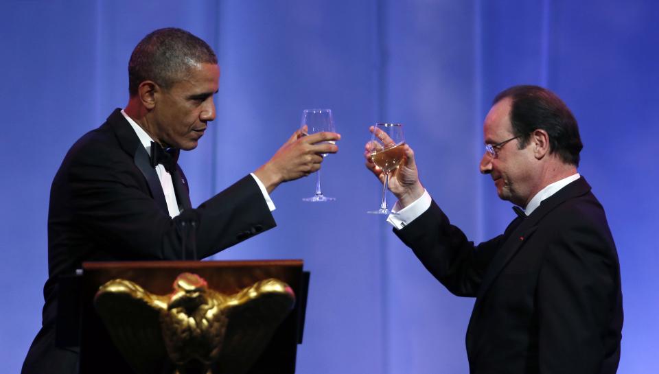 U.S. President Barack Obama (L) and French President Francois Hollande share a toast during a State Dinner in honor of Hollande at the White House in Washington February 11, 2014. (REUTERS/Kevin Lamarque)