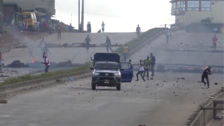 Protesters throw stones at a riot police vehicle on a main road in Sonfonia District in Conakry