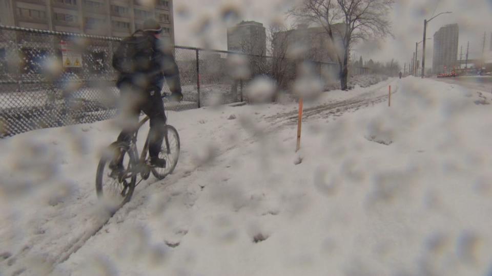 A cyclist makes their way through the snow in Ottawa in February 2020. Ottawa got nearly 15 millimetres of rain and 10 centimetres of snow Wednesday and it's kept falling. (CBC - image credit)