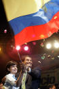 ARCHIVO - En esta foto de archivo del 26 de noviembre de 2006 el recién elegido presidente Rafael Correa y su esposa Anne Malherbe sostienen una bandera nacional durante la celebración de su victoria electoral en Quito. (AP Foto/Martin Mejía, Archivo)