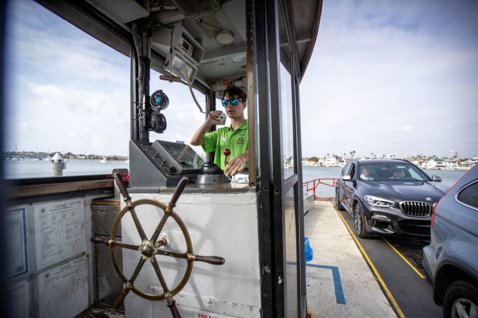 Capt. Dawson Carlson and vehicles on one of Balboa Island Ferry boats.