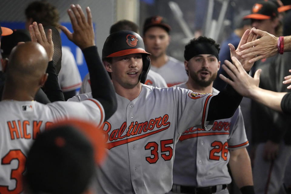 Baltimore Orioles' Adley Rutschman is congratulated by teammates in the dugout after scoring on a fielding error by Los Angeles Angels left fielder Randal Grichuk during the third inning of a baseball game Tuesday, Sept. 5, 2023, in Anaheim, Calif. (AP Photo/Mark J. Terrill)