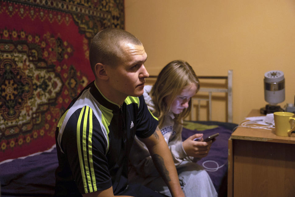 Oleksandr Mukhovatyi, 23, seats on the bed with his sister Ksiusha Mukhovata, 15, in the village of Hroza near Kharkiv, Ukraine, Friday, Oct. 6, 2023. Their parents were killed as the Russian rocket hit a village store and cafe in one of the deadliest attacks in recent months, killing at least 51 civilians. (AP Photo/Alex Babenko)