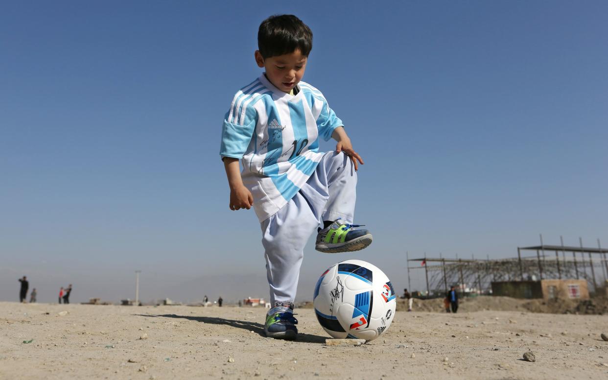 Murtaza Ahmadi, a five-year-old Afghan Lionel Messi fan plays in a shirt signed by Messi, in Kabul, Afghanistan - Copyright 2016 The Associated Press. All rights reserved. This material may not be published, broadcast, rewritten or redistribu
