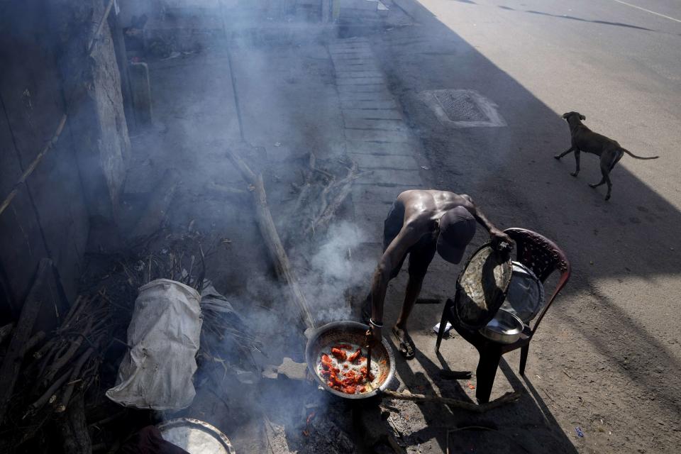 A man cooks food with firewood for his roadside eatery, amid shortage of cooking gas in Colombo, Sri Lanka, Thursday, June 23, 2022. Sri Lanka's prime minister says the island nation's debt-laden economy has "collapsed" as it runs out of money to pay for food and fuel. (AP Photo/Eranga Jayawardena)