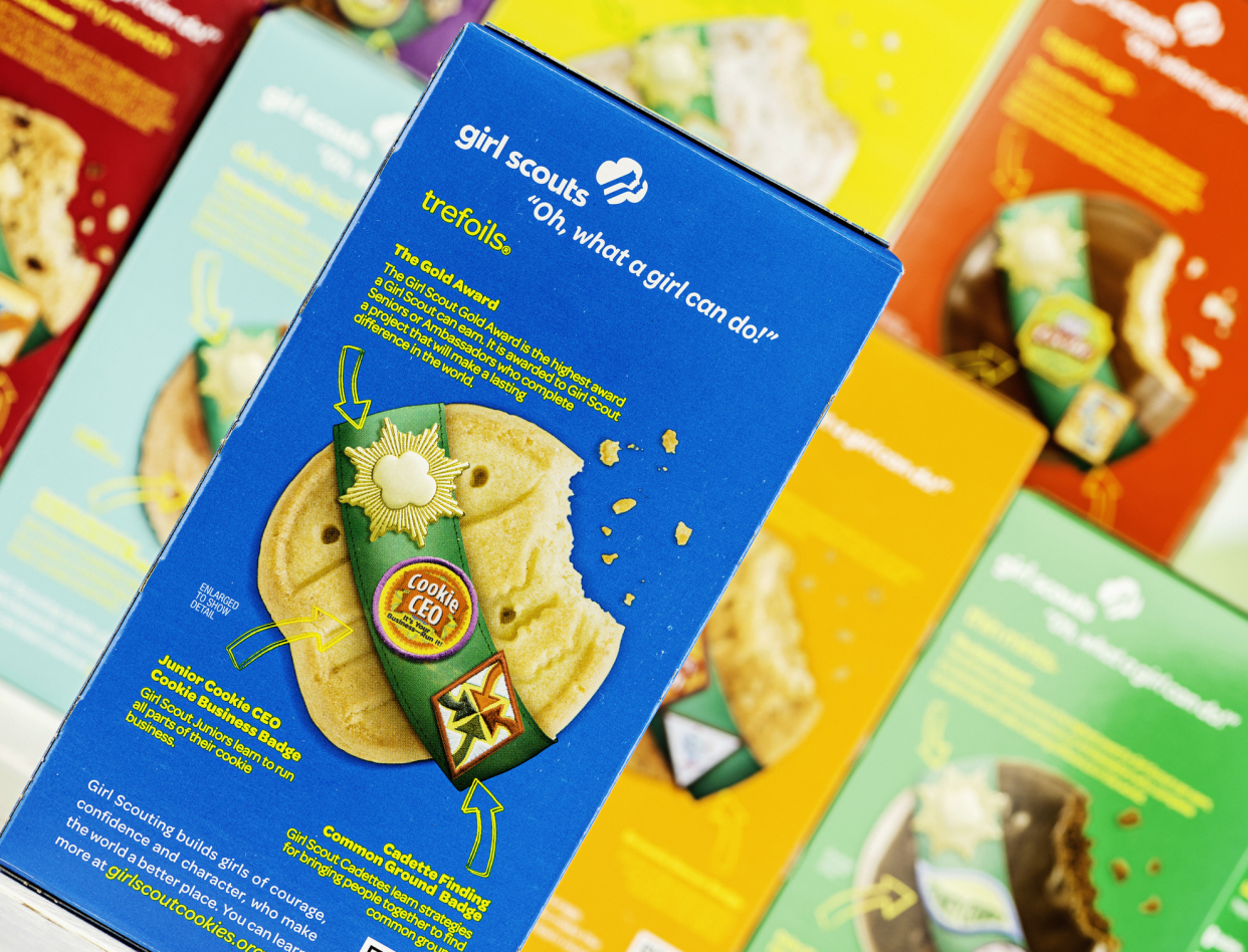 Box of Shortbread Girl Scout Cookies Over Blurred Background of Different Boxes of Girl Scout Cookies
