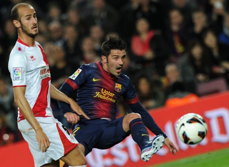 Barcelona forward David Villa (R) and Rayo Vallecano's Alex Galvez are pictured during their Spanish league match on March 17, 2013. Villa opened the scoring after teammate Lionel Messi had unlocked the Rayo defence on 25 minutes
