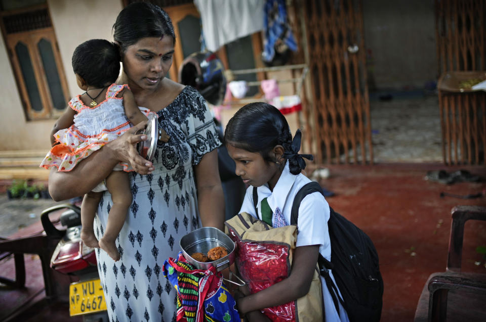 Rasarathnam Anushiya gives only two vadei, made from lentils, to her eight years old daughter Madushika in her lunch box before she leaves to school in Vavuniya, about 250 kilometres north east of Colombo, Sri Lanka, Wednesday, Dec. 14, 2022. Due to Sri Lanka's current economic crisis families across the nation have been forced to cut back on food and other vital items because of shortages of money and high inflation. Many families say that they can barely manage one or two meals a day. (AP Photo/Eranga Jayawardena)