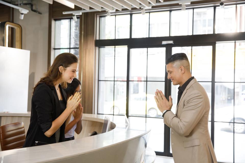 Je nachdem, wie respektvoll man sich der oder dem anderen gegenüber zeigen möchte, können beim "Wai" die Hände weiter nach oben gehalten und der Kopf weiter nach unten gebeugt werden. (Bild: iStock/bankerwin)