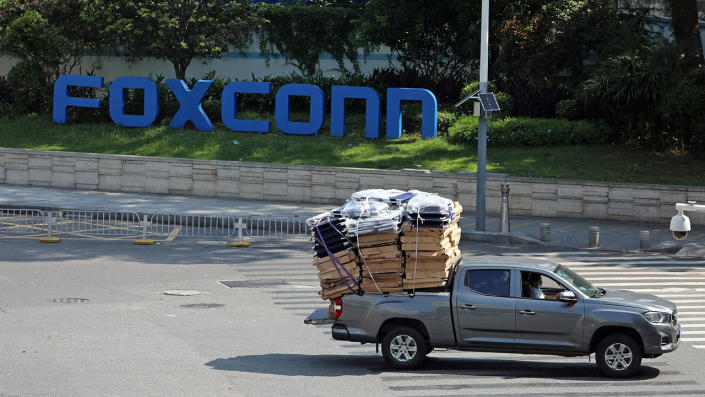 Truck with materials in the back drives in front of the Foxconn sign