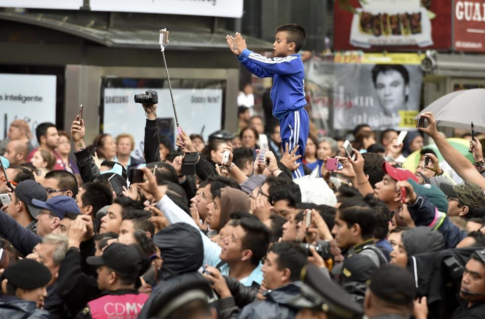 People gather outside the Palace of Fine Arts to pay tribute to Mexico's late Latin music legend Juan Gabriel.