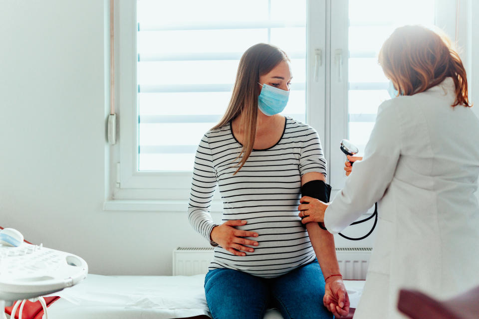 A pregnant person getting their blood pressure taken