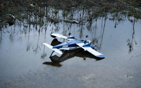 A plane is turned upside down after Hurricane Dorian - Credit: Brendan Smialowski/AFP