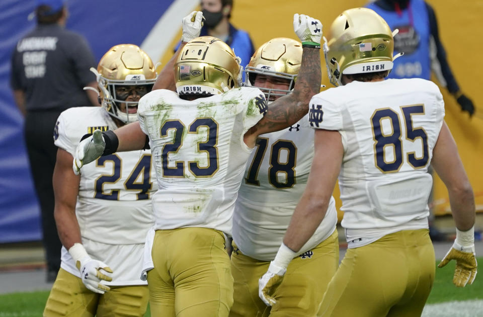 Notre Dame running back Kyren Williams (23) celebrates with teammates George Takacs (85), Tommy Kraemer (78) and Tommy Tremble (24) after scoring a touchdown against Pittsburgh during the first half of an NCAA college football game, Saturday, Oct. 24, 2020, in Pittsburgh. (AP Photo/Keith Srakocic)