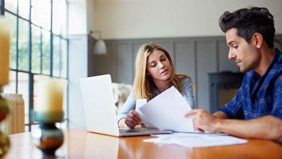 Shot of a couple going through some paperwork together at home.