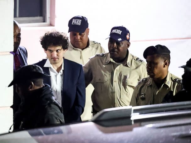 PHOTO: Sam Bankman-Fried, who founded and led FTX until a liquidity crunch forced the cryptocurrency exchange to declare bankruptcy, is escorted out of the Magistrate Court building after his arrest in Nassau, Bahamas, Dec. 13, 2022. (Dante Carrer/Reuters)