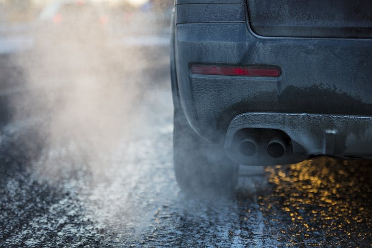 A car exhaust surrounded by fumes.