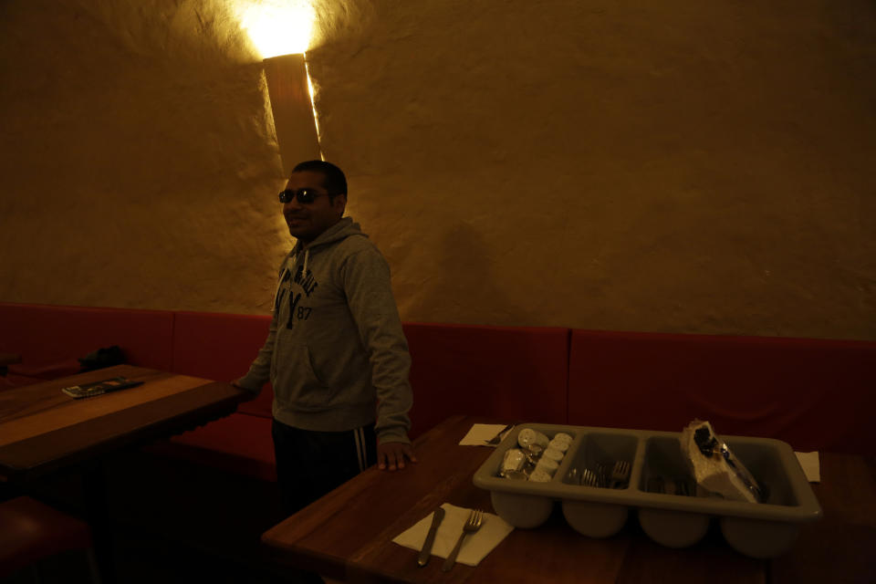 En esta imagen del 28 de octubre de 2017, el mesero ciego Oscar Pitiur espera a los comensales en el restaurante “La Cueva de Rafa”, en Quito, Ecuador. (AP Foto/Dolores Ochoa)