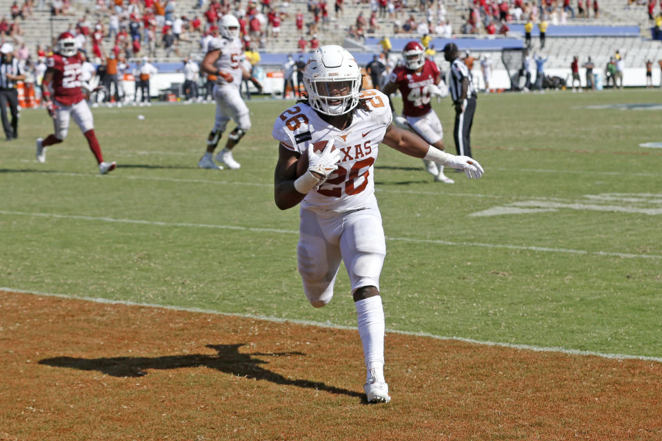 Texas running back Keaontay Ingram (26) scores a touchdown against Oklahoma during the second half of an NCAA college football game in Dallas, Saturday, Oct. 10, 2020. Oklahoma defeated Texas 53-45 in four overtimes.(AP Photo/Michael Ainsworth)