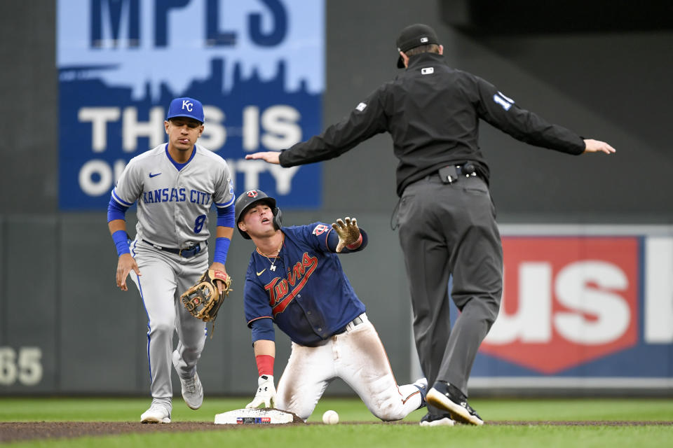 Umpire Adam Beck, right, calls Minnesota Twins' Jose Miranda, center, safe at second base with a double, next to Kansas City Royals second baseman Nicky Lopez during the fourth inning of a baseball game Thursday, May 26, 2022, in Minneapolis. (AP Photo/Craig Lassig)